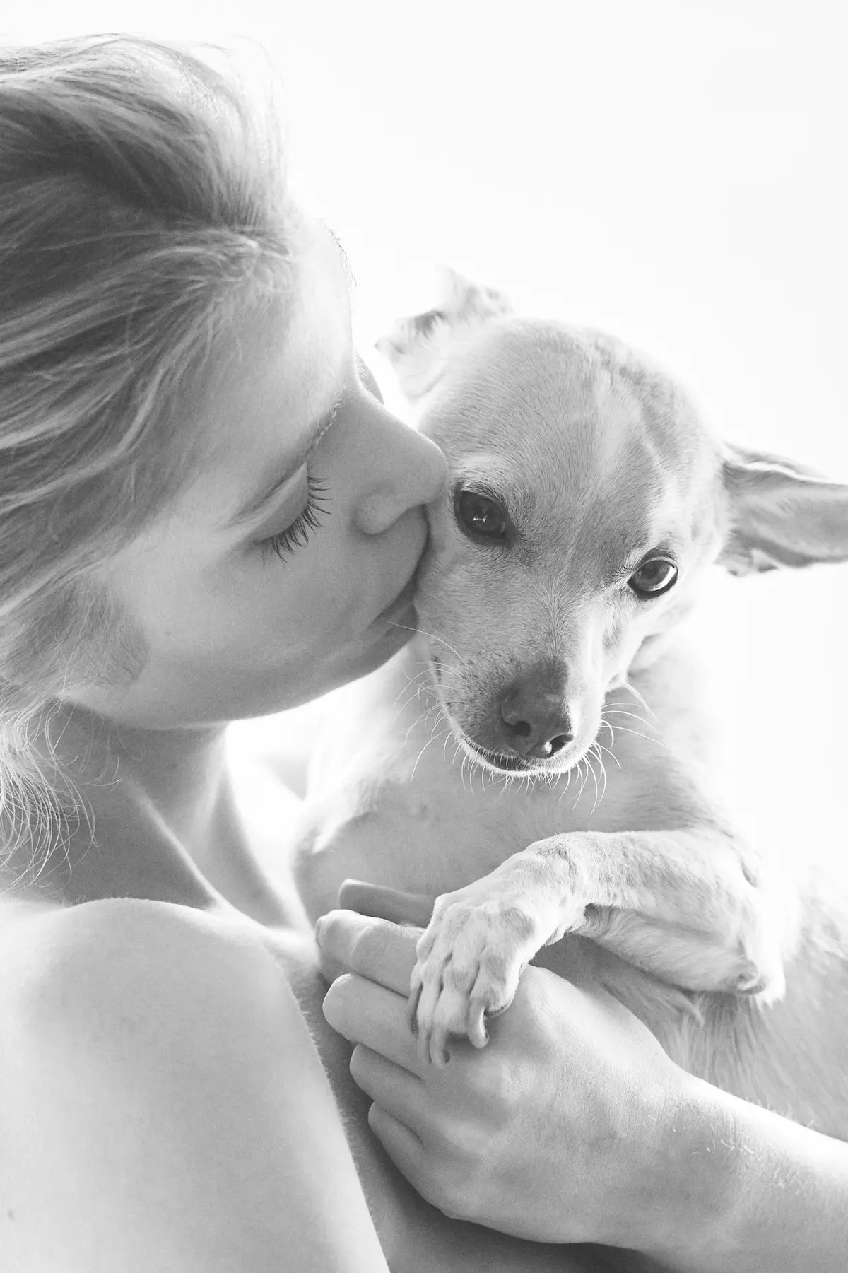 Stella Maxwell kisses her chihuahua-terrier, Trip, sharing a tender moment. The close-up captures the bond between Stella and her beloved dog, Trip, emphasizing the affection and love they share.